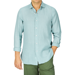 Man wearing a Sage Green Linen Casual Shirt from Finamore and olive pants against a plain background.
