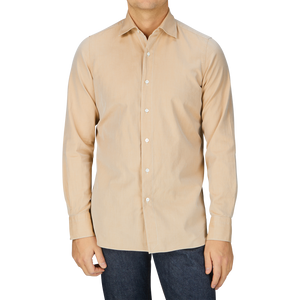 A man wearing a Sand Beige Washed Cotton Twill Shirt from Finamore and jeans.