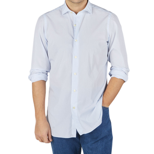 A man wearing a washed light blue striped cotton Finamore shirt and jeans.