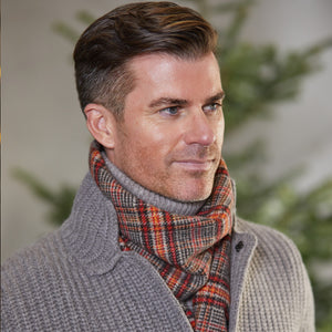 A man wearing a Fox Brothers Negroni Checked Lambswool Cashmere Scarf, knitted in England.