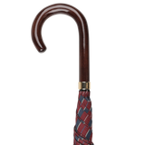 A handmade Fox Umbrellas creation, the Red Blue Striped Maple Handle Umbrella features a wooden crook handle and a burgundy and blue checkered fabric, rolled and closed.