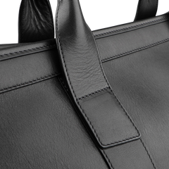 A close-up of Frank Clegg's Black Tumbled Leather Signature Duffle showcases the exquisite strap and intricate stitching details.