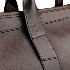 Close-up of the Frank Clegg Chocolate Tumbled Leather Small Travel Duffle showcasing visible stitching and texture details, featuring an adjustable shoulder strap for versatility.