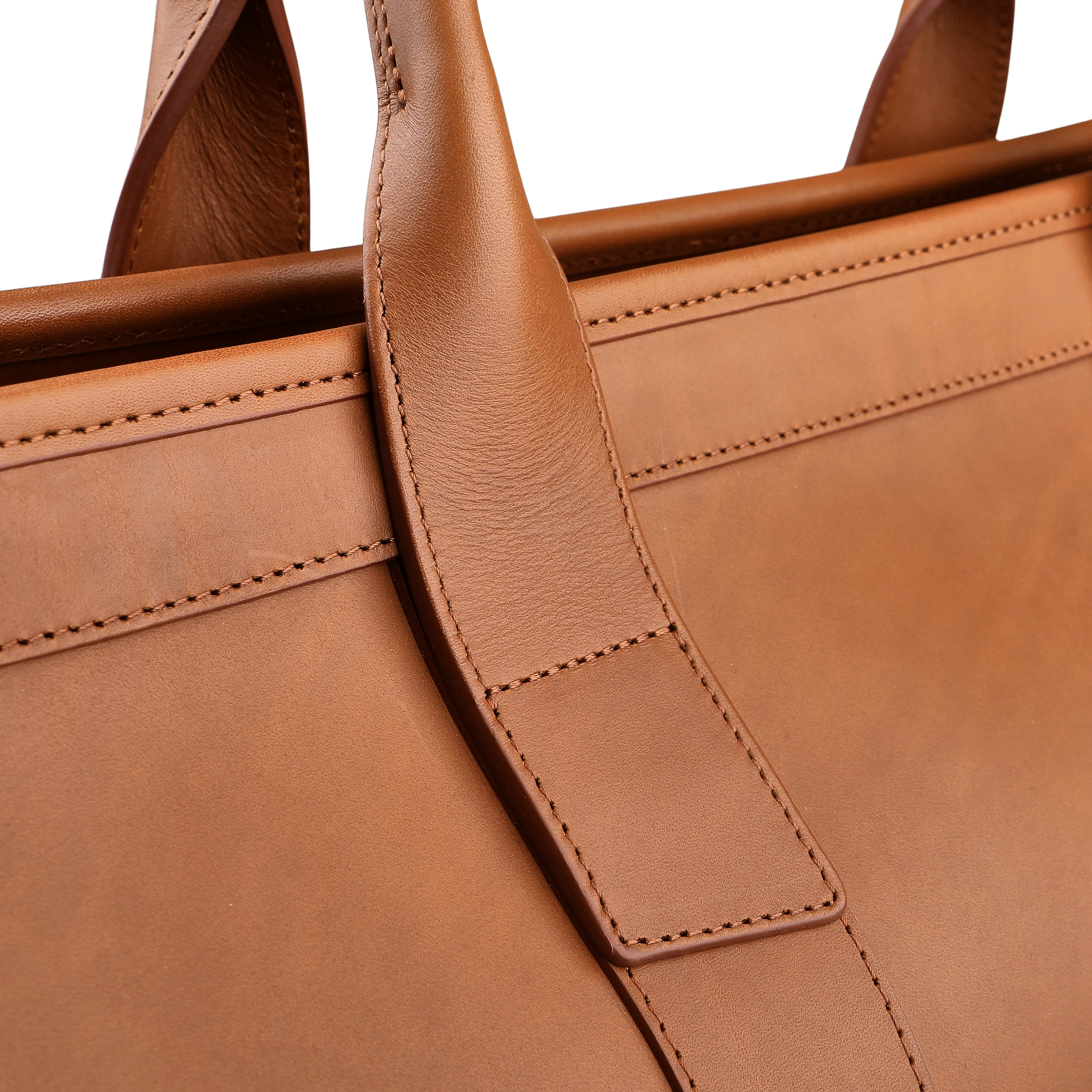 Close-up of the Frank Clegg Cognac Harness Belting Leather Signature Duffle highlighting its hand-crafted quality, with a focus on the handle and intricate stitching details made from premium leather.