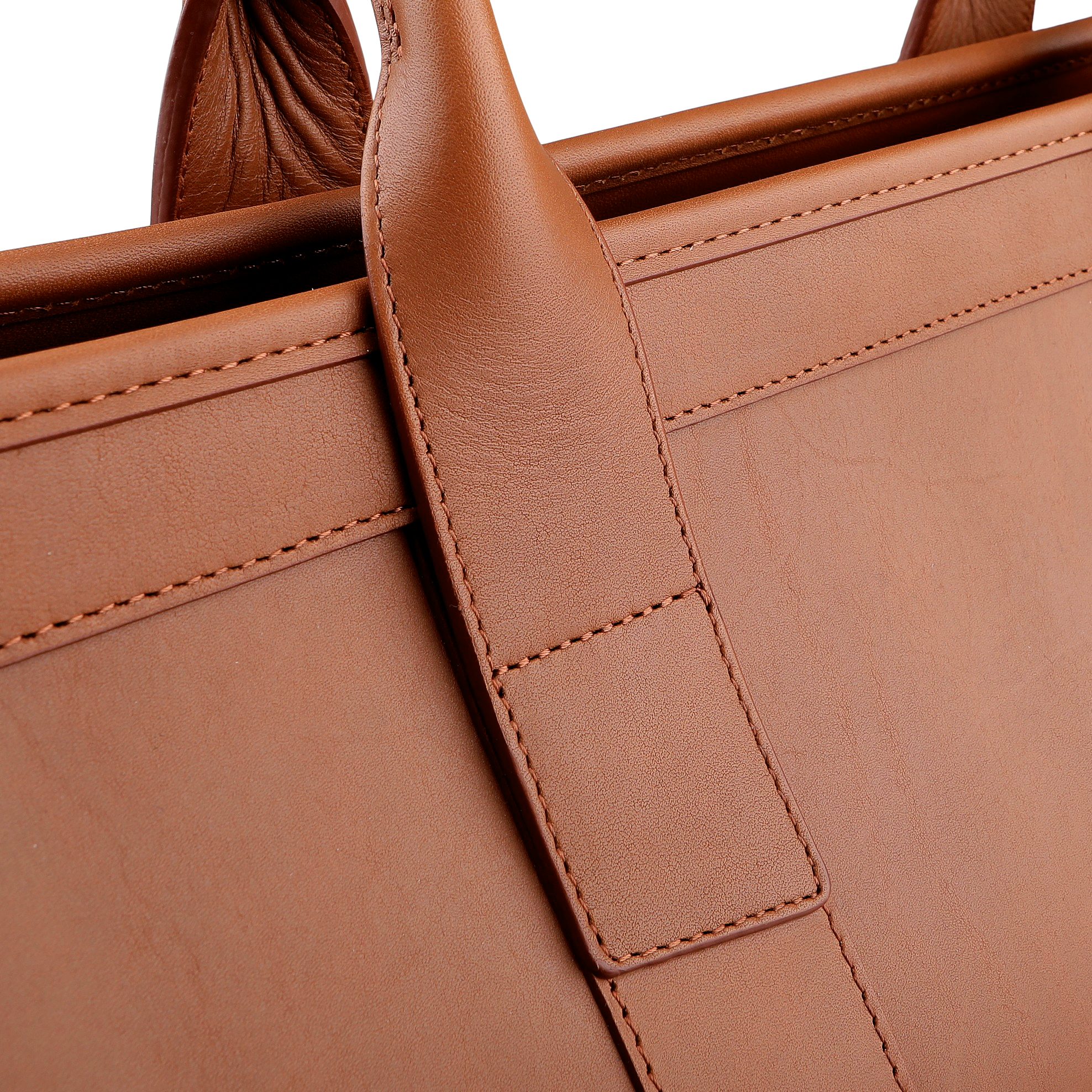 Close-up of Frank Clegg's Cognac Harness Leather Small Travel Duffle, showcasing the intricate stitching on the handle and body.