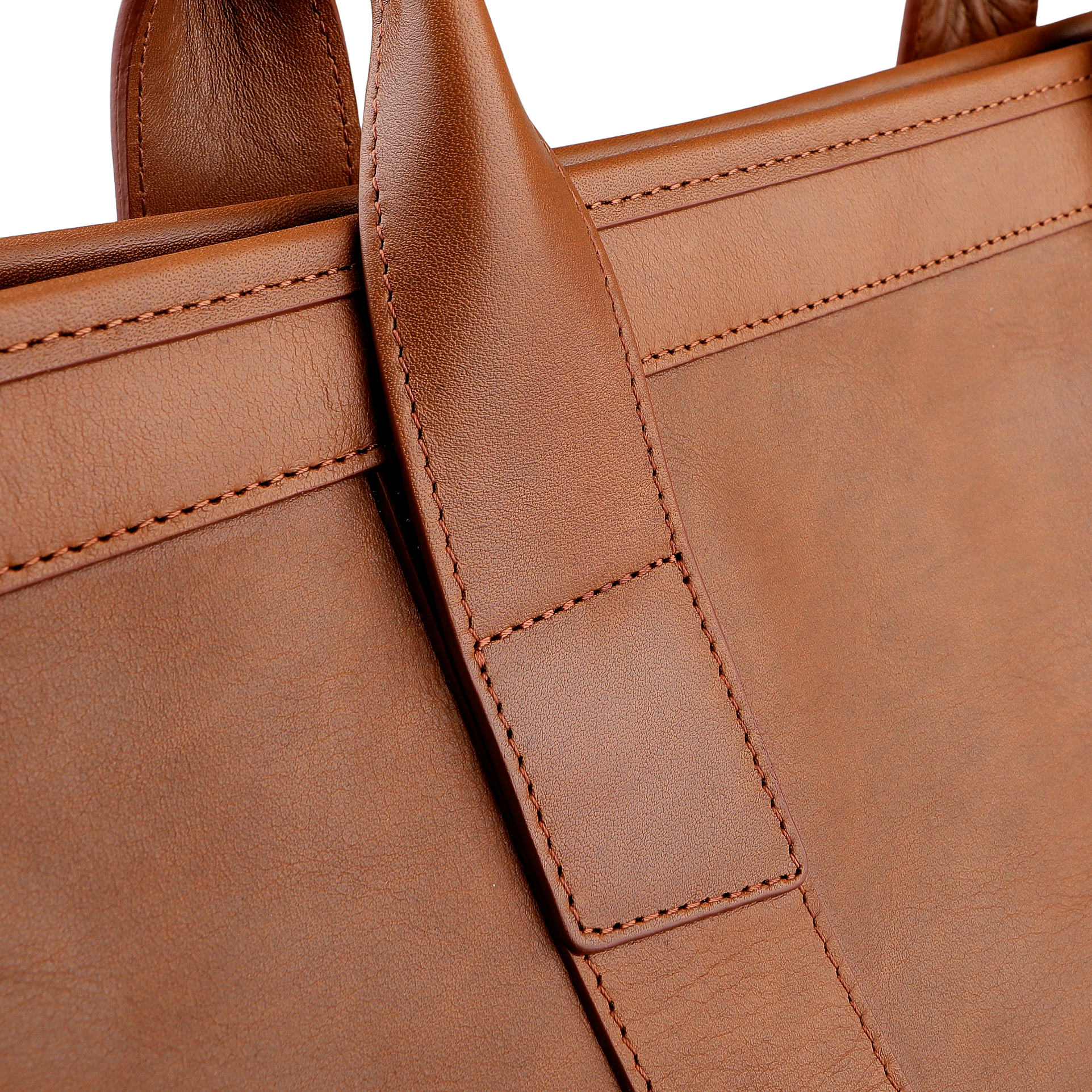 A close-up of Frank Clegg's Cognac Tumbled Leather Signature Duffle emphasizes its luxurious, hand-crafted quality with a focus on the handle and intricate stitching details.