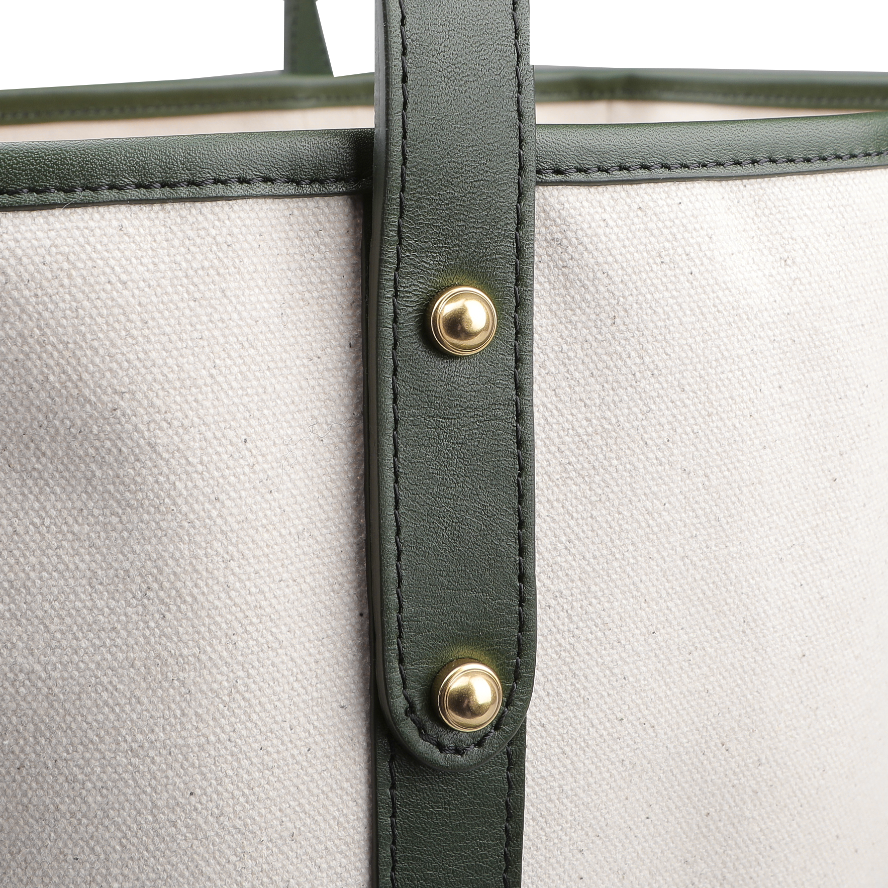 Close-up of the Frank Clegg Natural Canvas Tumbled Leather Market Tote Bag, featuring green leather trimmings and brass rivets.