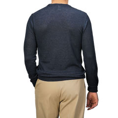 A person wears a Dark Blue Linen Crewneck Sweater by G.R.P and beige pants, facing away.