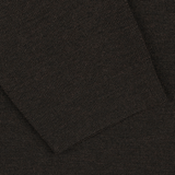 Close-up view of the Brown Melange Wool Crewneck Sweater by G.R.P., showcasing a dark brown melange knit fabric with a rectangular piece layered on top, reminiscent of the texture found in a seasonal crewneck sweater.