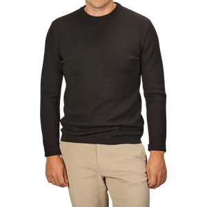 A man wearing a G.R.P Brown Melange Wool Crewneck Sweater and beige pants, facing forward with arms relaxed at his sides. His head is partially out of the frame.