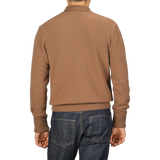 A person wearing a Camel Beige Wool Cashmere Mock Neck Sweater by G.R.P and blue jeans is shown from the back.