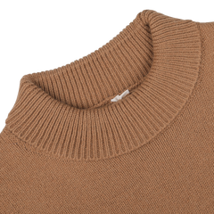 Close-up of a camel beige wool cashmere mock neck sweater by G.R.P, featuring a visible clothing tag at the collar, combining wool and cashmere for ultimate comfort.