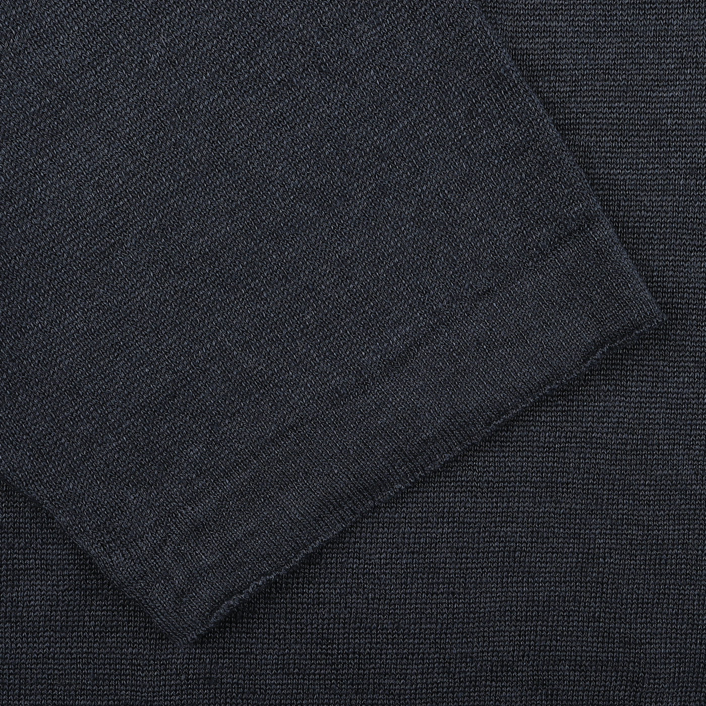 Close-up of a dark gray textured fabric with visible seam, showing intersecting threads, reminiscent of the fine craftsmanship seen in G.R.P's Dark Blue Linen Polo Shirt.