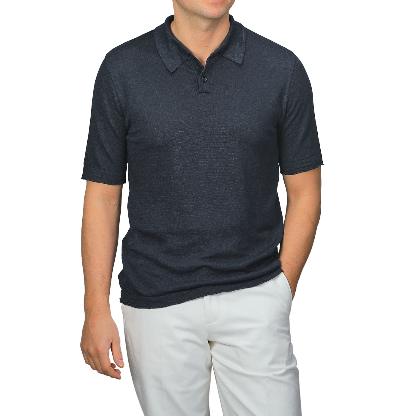 A man poses with one hand in his pocket against a plain background, wearing a dark blue linen polo shirt by G.R.P paired with light-colored pants.