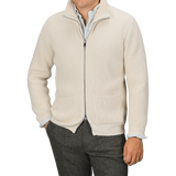 A person is wearing a G.R.P Ecru Beige Wool Cashmere Knitted Jacket over a white collared shirt and dark trousers. The full-zip ribbed cardigan, which features pockets on both sides, obscures the person's face from view.