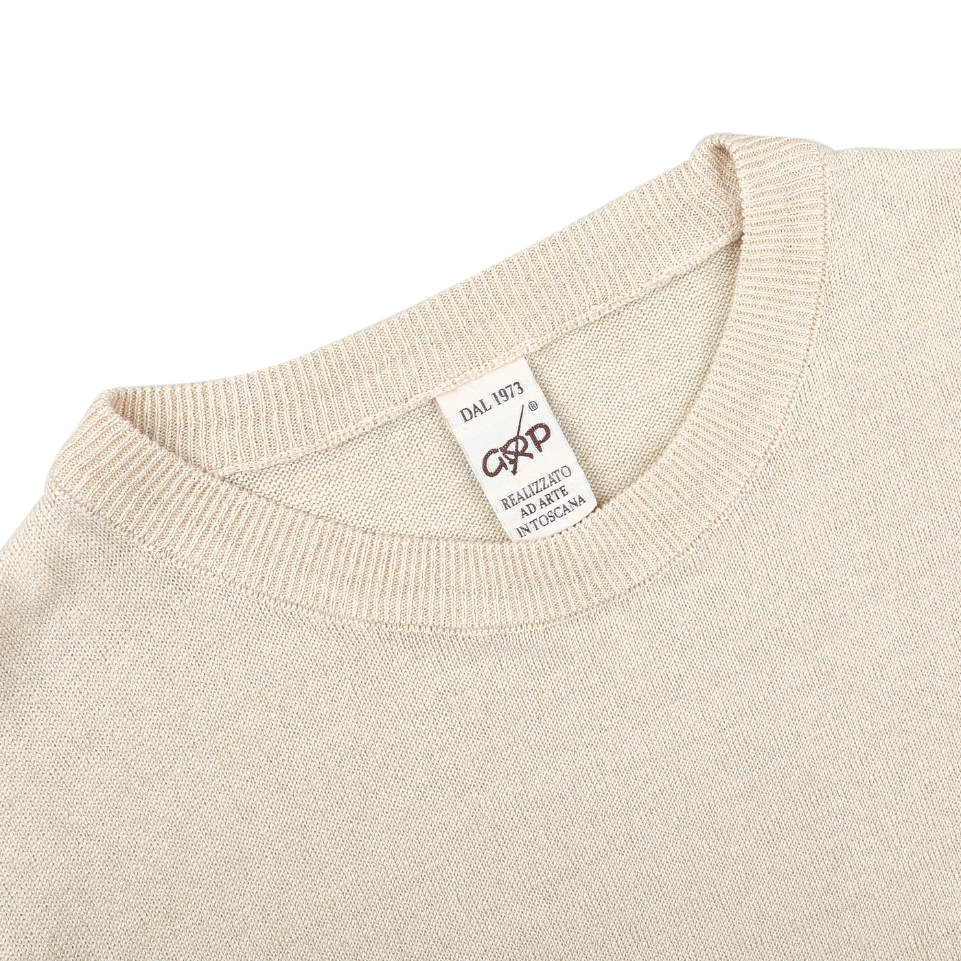 A close-up of an Ecru Beige Linen Crewneck Sweater, designed with a slim fit, features a tag reading "DAL 1973" and "MADE IN ITALY" from the brand G.R.P.