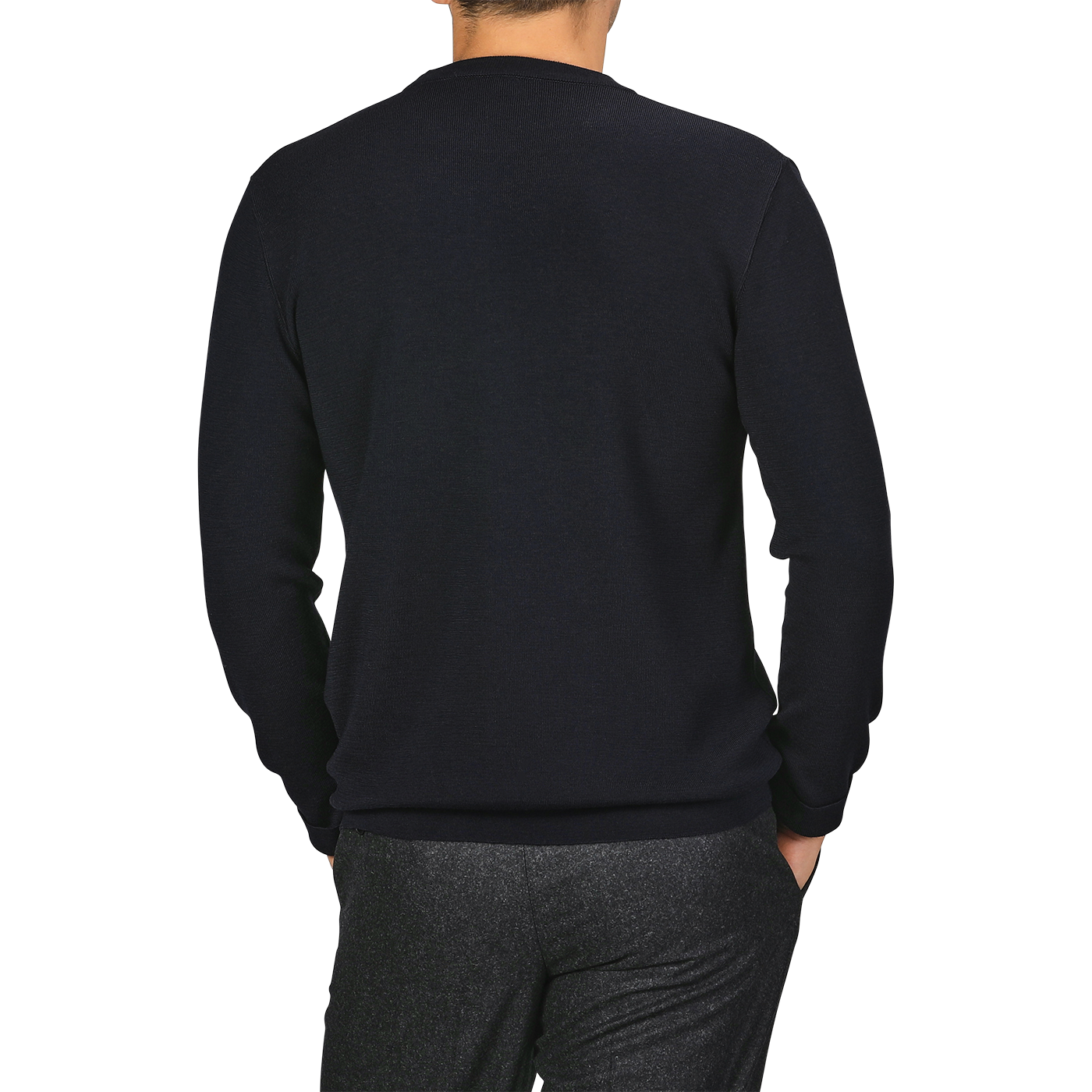 A person is standing with their back to the camera, wearing a Night Blue Wool Crewneck Sweater from G.R.P and gray pants.