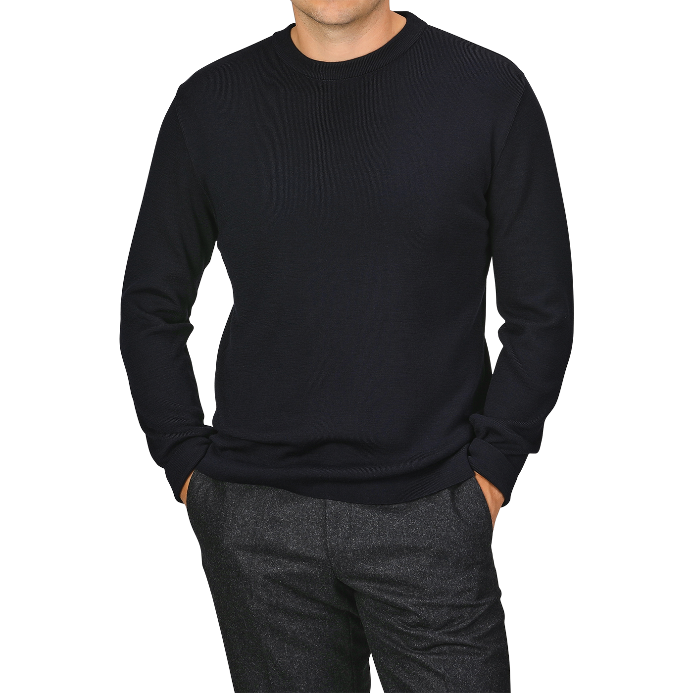 A person stands with hands in pockets, wearing a plain black long-sleeve shirt and gray trousers. Their head is not visible, but the outfit could be complemented perfectly with the night blue wool crewneck sweater from G.R.P for added elegance.