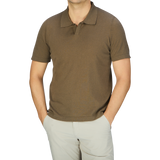 A man wearing a Olive Green Cotton Linen Polo Shirt by G.R.P and khaki pants.