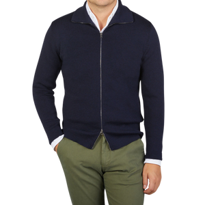 A man wearing a G.R.P navy blue merino wool zip jacket and green pants made of pure merino wool.