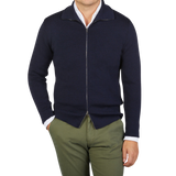 A man wearing a G.R.P navy blue merino wool zip jacket and green pants made of pure merino wool.