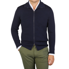 A man wearing a G.R.P navy blue merino wool zip jacket and green pants made of pure merino wool.