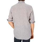 Man wearing a Glanshirt brown melange linen regular fit shirt, rolled-up sleeve and jeans, viewed from behind.