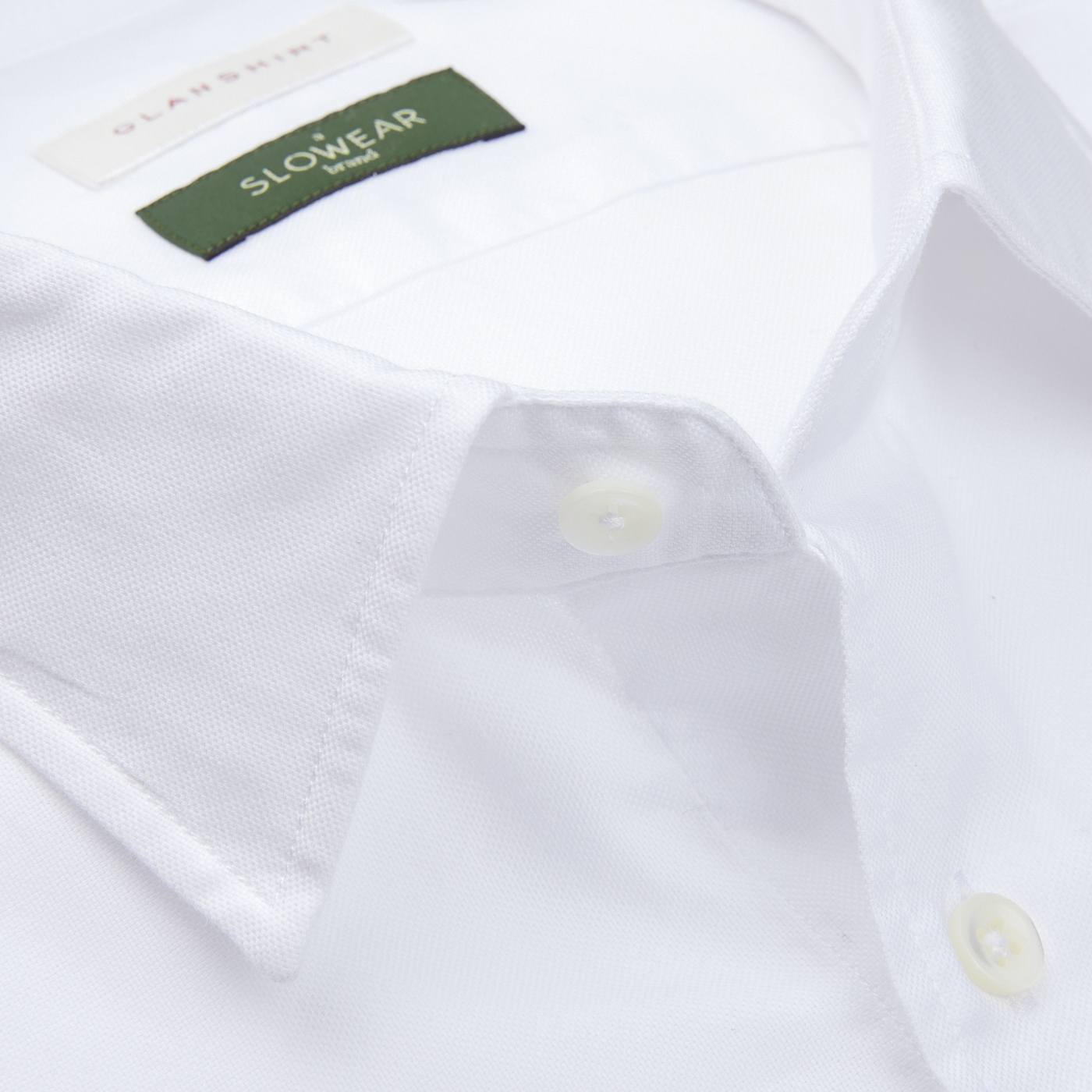 Close-up of a white Glanshirt Cotton Oxford Regular Shirt with a tag labeled "slowear," featuring mother-of-pearl buttons.