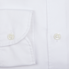 Close-up of a Glanshirt white cotton oxford regular shirt detailing a buttoned sleeve and placket with mother-of-pearl buttons.