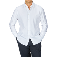 Man wearing a Glanshirt White Cotton Oxford Regular Shirt with mother-of-pearl buttons and dark trousers.