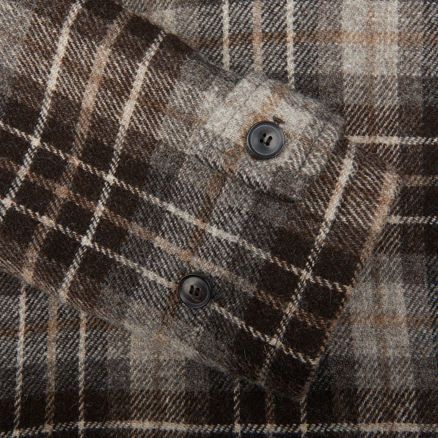 A close up of a De Bonne Facture Brown Undyed Shepherds Check Wool Duffle Coat.