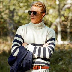 A man wearing a Gloverall Ecru Blue Striped Wool Rollneck sweater and sunglasses.