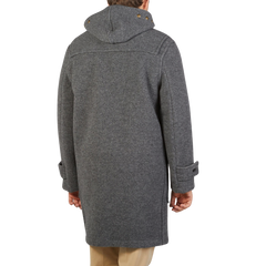 The back view of a man in a Gloverall Grey Melange Wool Monty Duffle Coat.