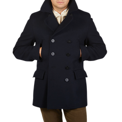 A man wearing a navy Gloverall Navy Wool Churchill Peacoat made of English Melton wool.