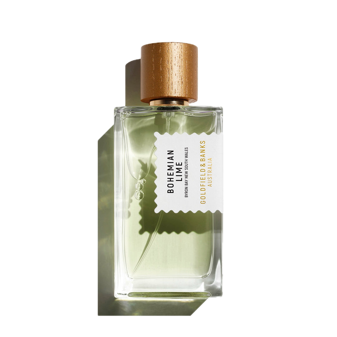 A clear rectangular bottle of Bohemian Lime 100ml Eau De Parfum, adorned with a gold cap and a label that declares its identity as "Goldfield & Banks Australia." This invigorating fragrance captivates with notes of lime, beautifully complemented by earthy vetiver undertones, offering an unforgettable olfactory journey.