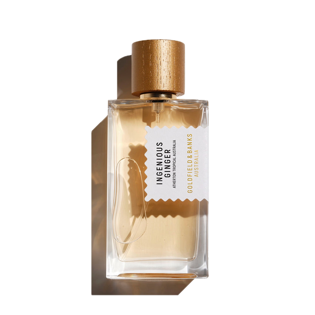 The Ingenious Ginger 100ml Eau De Parfum by Goldfield & Banks comes in a transparent rectangular bottle adorned with a gold cap and a white label, featuring citrusy hints of mandarin.