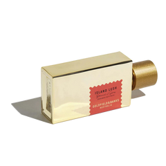 A rectangular gold bottle of "Island Lush" 100ml Eau De Parfum from Goldfield & Banks, featuring a red accent and exuding an exotic allure.