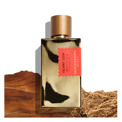 A rectangular bottle of Island Lush 100ml Eau De Parfum by Goldfield & Banks, adorned in gold and set against a backdrop of wood and root textures, captures the exotic allure of lush landscapes with hints of sandalwood.