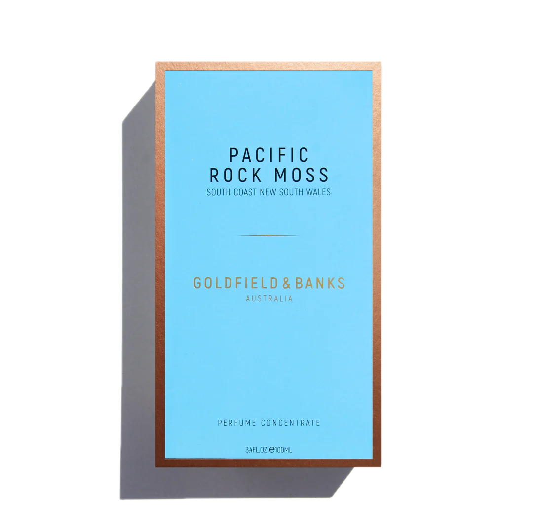 The "Pacific Rock Moss" 100ml Eau De Parfum by Goldfield & Banks, housed in a blue box with a bronze border, captures the fresh essence of sea spray scent.