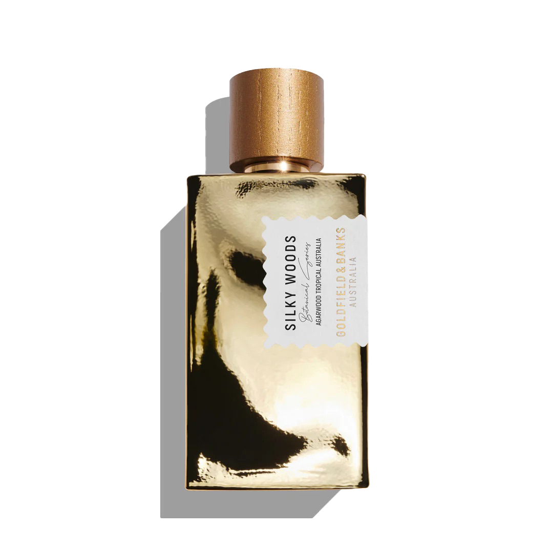 The Goldfield & Banks "Silky Woods 100ml Eau De Parfum" features a glistening golden cap and reflective surface, embodying elegance and allure.