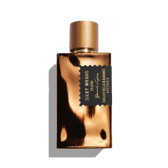 A gold perfume bottle labeled "Silky Woods Elixir 100ml Extrait de Parfum" by Goldfield & Banks, infused with the essence of exotic botanicals and featuring a sleek black and gold cap.