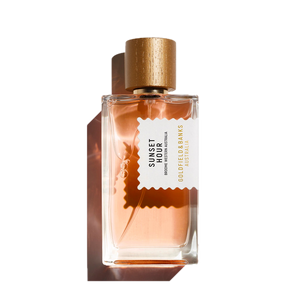 A bottle of Goldfield & Banks Sunset Hour 100ml Eau De Parfum features a gold cap and a peach-colored liquid inside, offering an exquisite blend of spicy notes with subtle floral hints for a unique olfactory experience.