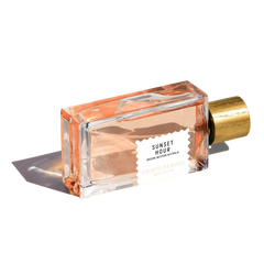 The "Sunset Hour" 100ml Eau De Parfum by Goldfield & Banks, topped with a golden cap and artfully angled on a white background, releases a citrus fragrance that embodies the sophistication of twilight elegance.