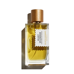 A clear glass bottle of Velvet Splendour 100ml EdP reveals its golden yellow liquid, capped with wood and featuring a white label that reads "Goldfield & Banks." Infused with the magical notes of the mimosa tree, it embodies the essence of blooming wildflowers.