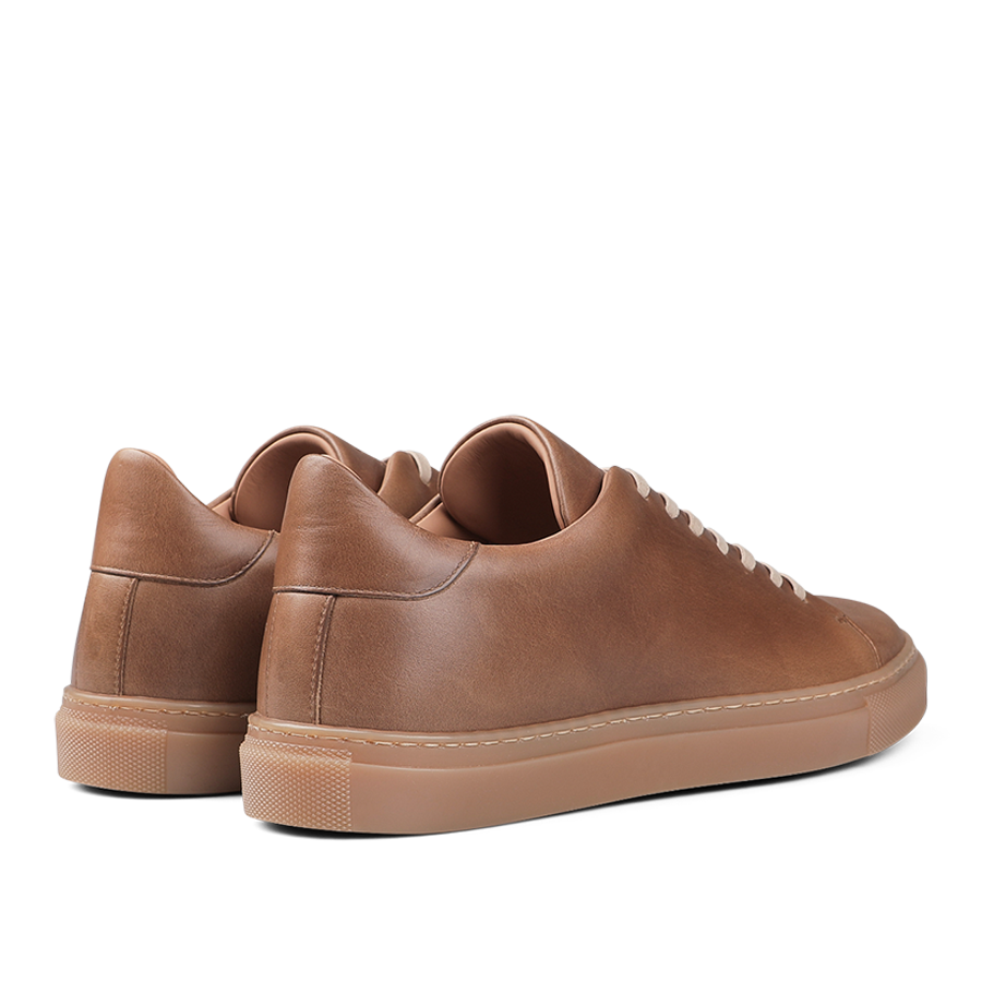 A pair of Goral's Brown Horween Leather Mellor II Sneakers, showcasing premium-quality craftsmanship with beige soles, viewed from the back.