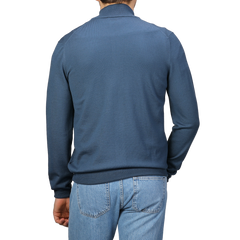 A person is seen from the back against a plain background, wearing an Airforce Blue Extrafine Merino Wool Zip Cardigan by Gran Sasso and light blue jeans.