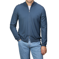 A person wearing a Gran Sasso Airforce Blue Extrafine Merino Wool Zip Cardigan and light blue jeans stands against a plain background.