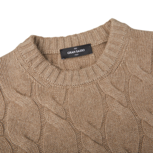 A Gran Sasso Beige Cashmere Cableknit Crewneck Sweater with a label on it that is perfect for any wardrobe.