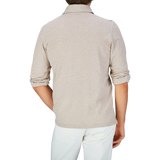 Rear view of a person wearing a Gran Sasso Beige Cotton Jersey Popover Shirt with rolled-up sleeves and white pants.