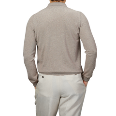 A person is shown from the back wearing a beige extra fine Merino wool polo shirt by Gran Sasso and light khaki pants.